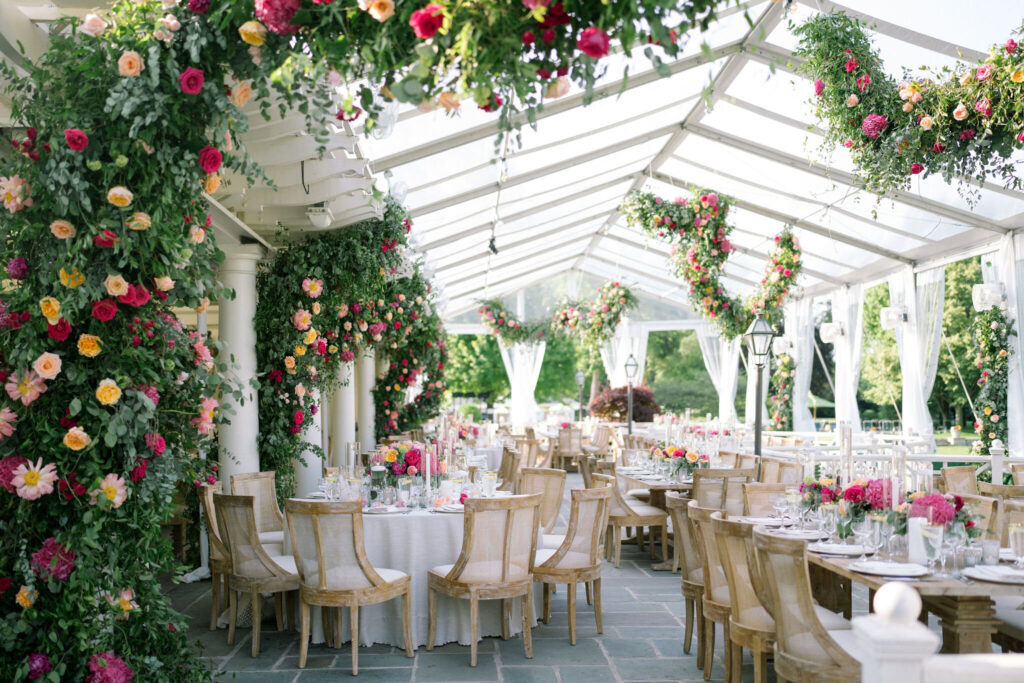 Tented wedding reception with large floral arrangements draping at the Saddle & Cycle Club