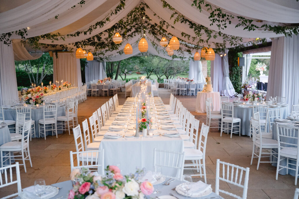 Tented reception with long tables with pink and white flower centerpieces at the Chicago Botanic Garden